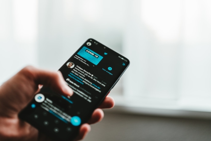 A user scrolling Twitter on their phone.