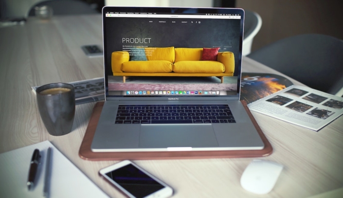 A laptop computer on a desk showing an online shop for furniture