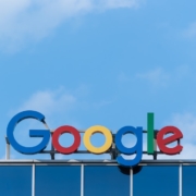 A "Google" sign on top of a building in front of a blue sky